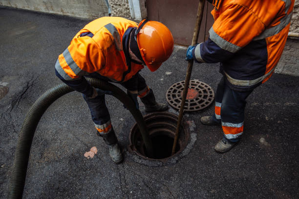 sewer workers cleaning manhole and unblocking sewers the street sidewalk.